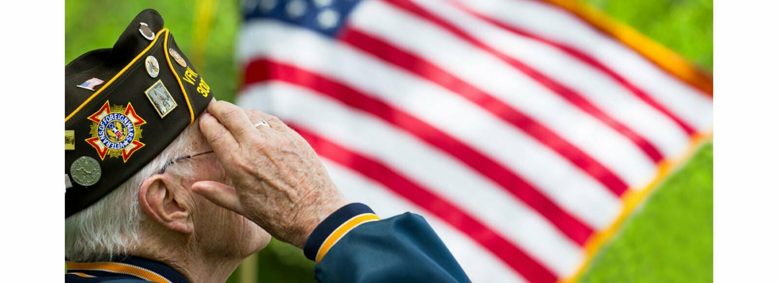 Senior veteran saluting American flag