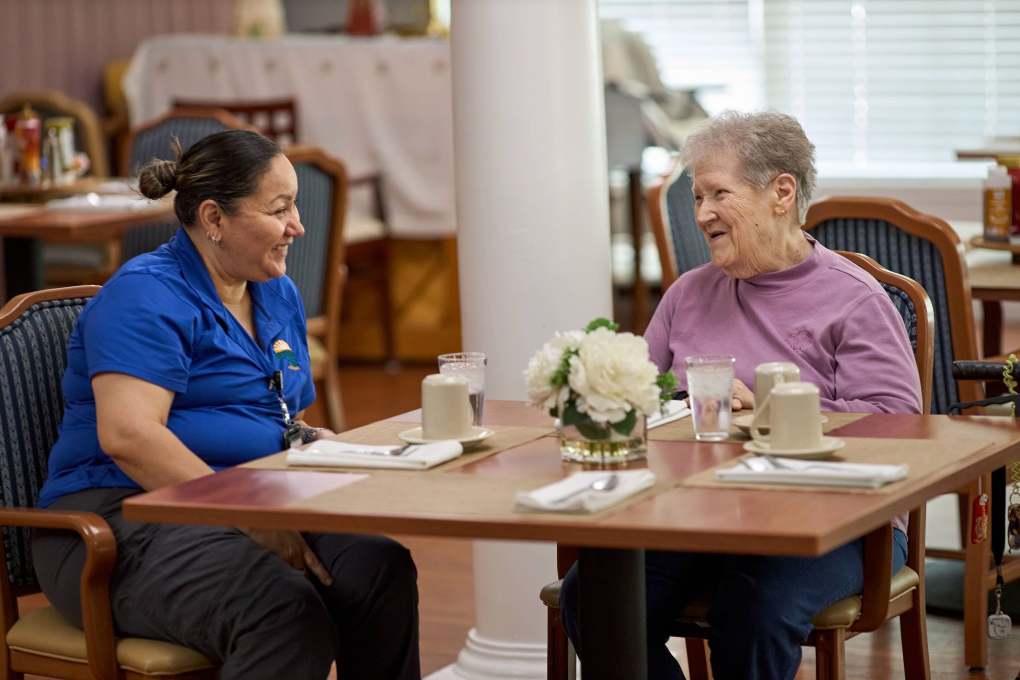 Dayspring Villa Assisted Living Community in Denver, CO - resident with staff enjoying coffee large landscape