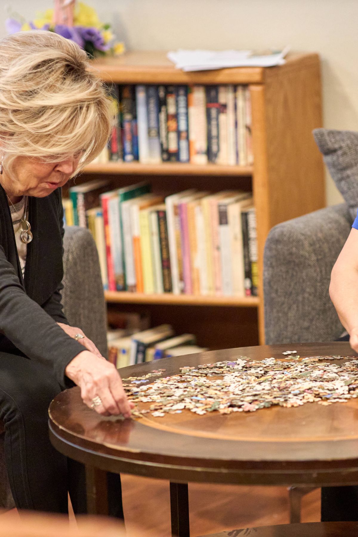 Dayspring Villa Assisted Living Community in Denver, CO - staff and resident solving jigsaw puzzle portrait